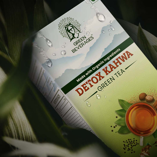 The box features a steaming cup of tea, spices like black pepper, cloves, and cinnamon, and a woman in traditional attire. The text on the box highlights the use of organic ingredients and the detoxifying properties of Detox Kahwa Tea.