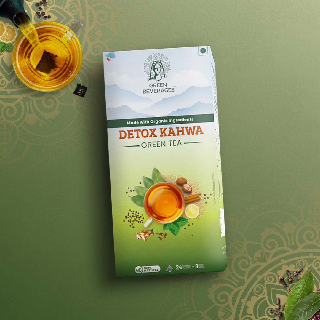 A green tea box with the brand name "Green Beverages" and the product name "Detox Kahwa Green Tea." The box features a woman in traditional attire, a steaming cup of tea, and various spices. The text on the box highlights the use of organic ingredients and the detoxifying properties of the tea.