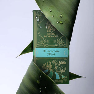 A green tea box with a gold border, featuring a Moroccan mint illustration. 