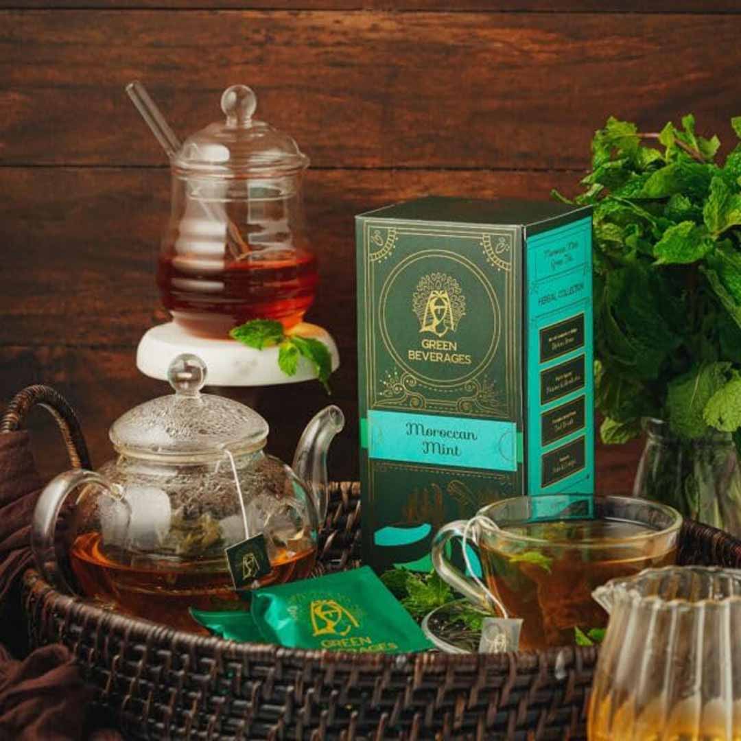 A Moroccan mint tea set featuring a green tea box, teapot, teacups, and honey jar. Ideal for brewing refreshing and aromatic peppermint tea.