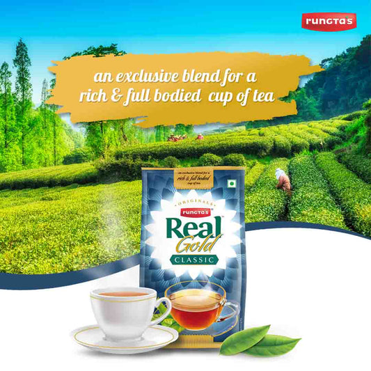 Rungta's Real Gold Classic Darjeeling tea packet, a premium blend for a rich and full-bodied cup of tea. The packaging features a blue and gold design with the brand logo and the product name. The image also shows a steaming cup of tea and a tea plantation in the background.